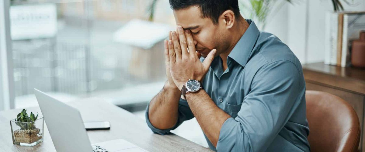 Man sitting at desk looking stressed | OpenRad Stress management 10 great self-care tips